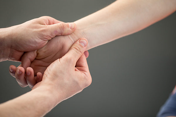 Hand massage -- a pair of hands massaging another person's wrist